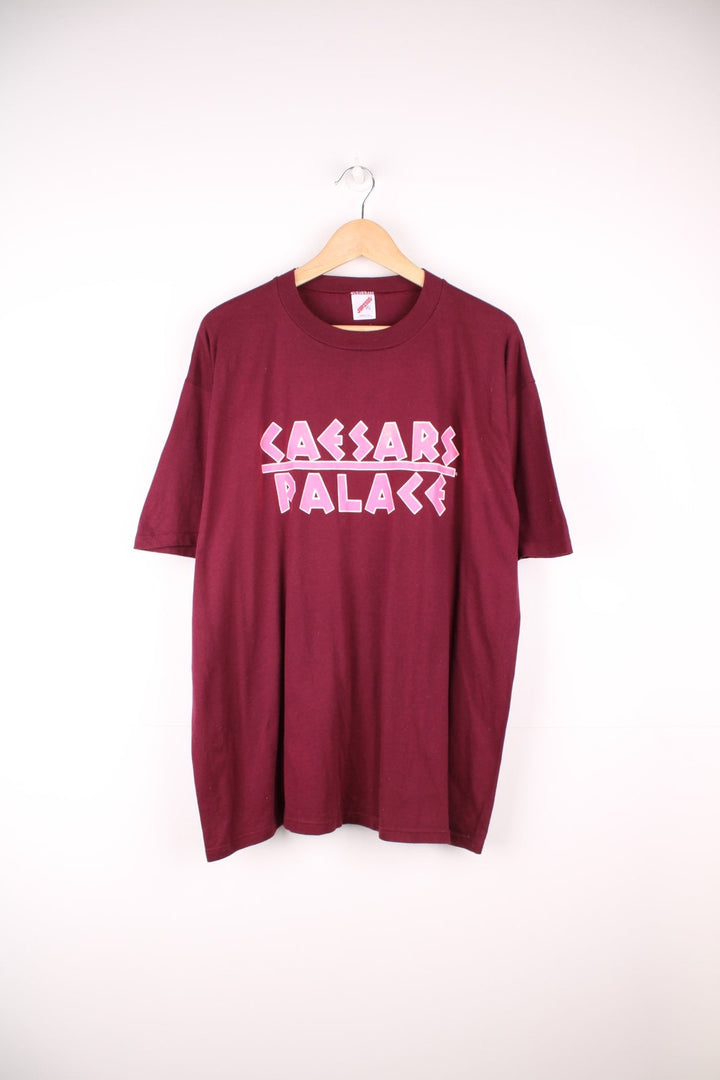 Vintage 80s Caesars Palace single stitch T-Shirt in burgundy red with neon pink print across the chest and back.