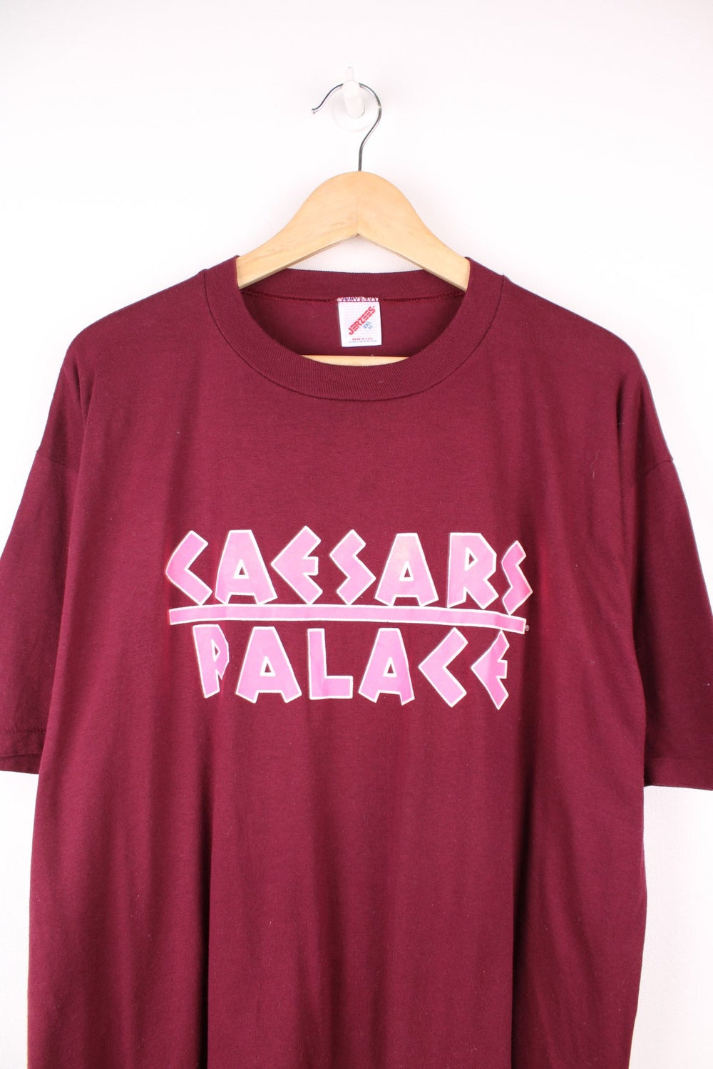 Vintage 80s Caesars Palace single stitch T-Shirt in burgundy red with neon pink print across the chest and back.