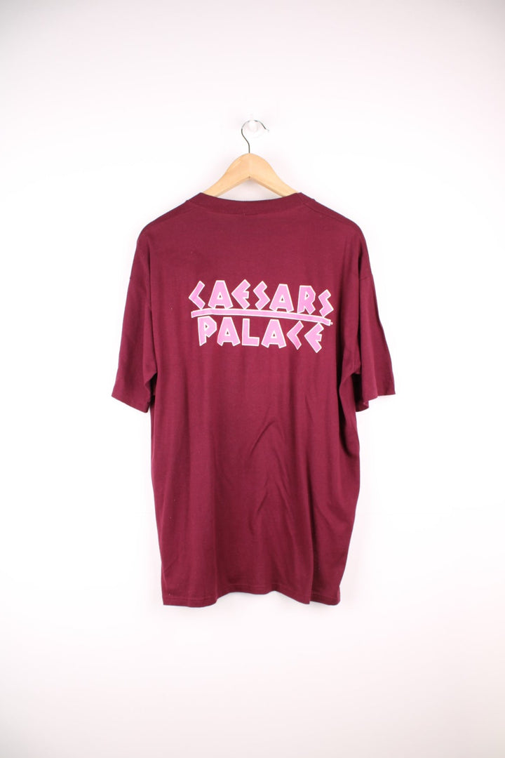 Vintage 80s Caesars Palace single stitch T-Shirt in burgundy red with neon pink print across the chest and back.