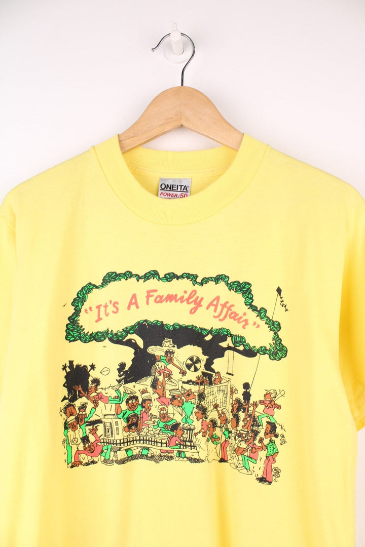 Vintage yellow graphic United Health Plan tee with cartoon design reading 'It's a Family Affair', and a Watts Health Foundation sponsorship logo on the right sleeve. 