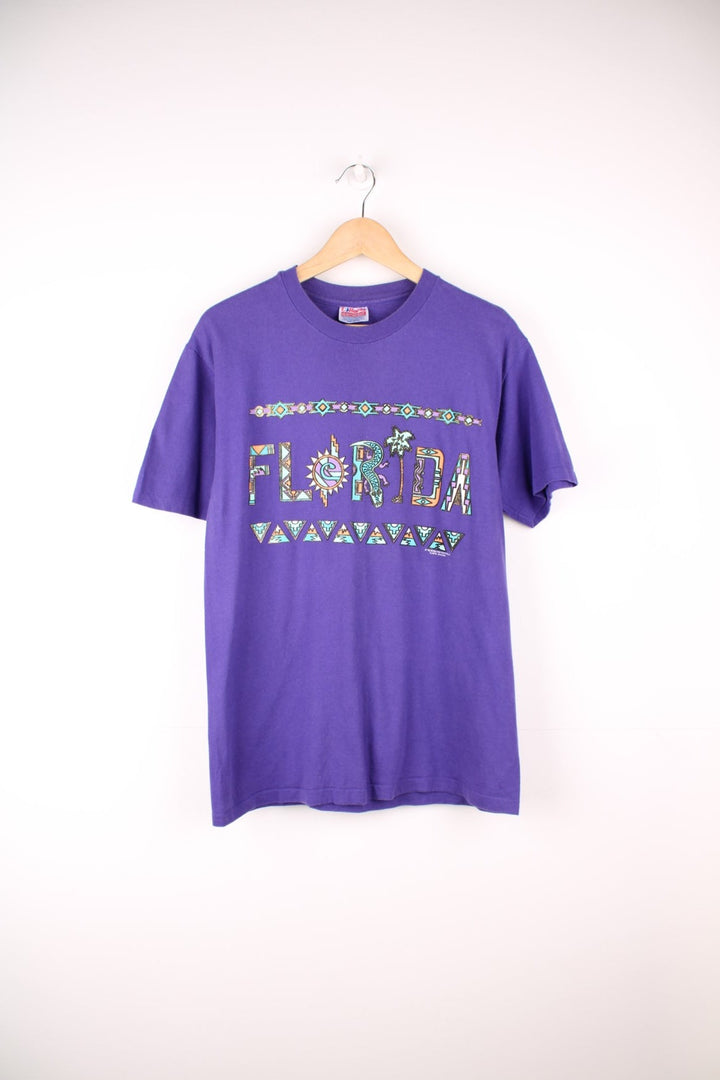 Purple Florida spellout tee with geometric designs. 