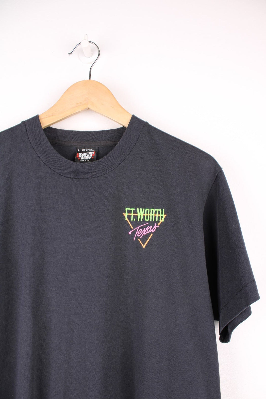 Black tee with 'Ft. Worth, Texas' embroidered in neon collars on the left. 