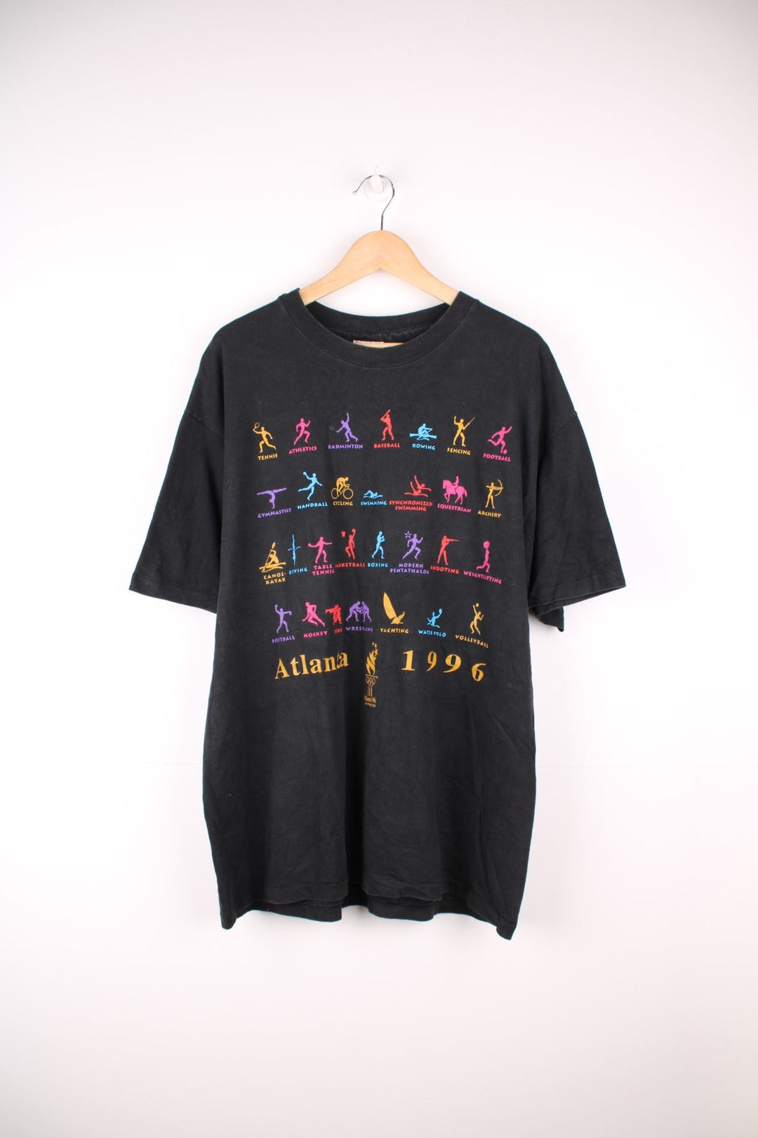 Atlanta 1996 Olympics tee in black with multicoloured designs of each sport including athletics, fencing, tennis.