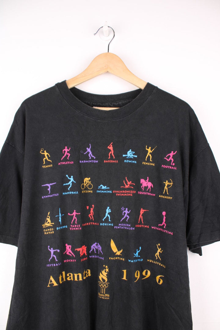 Atlanta 1996 Olympics tee in black with multicoloured designs of each sport including athletics, fencing, tennis.