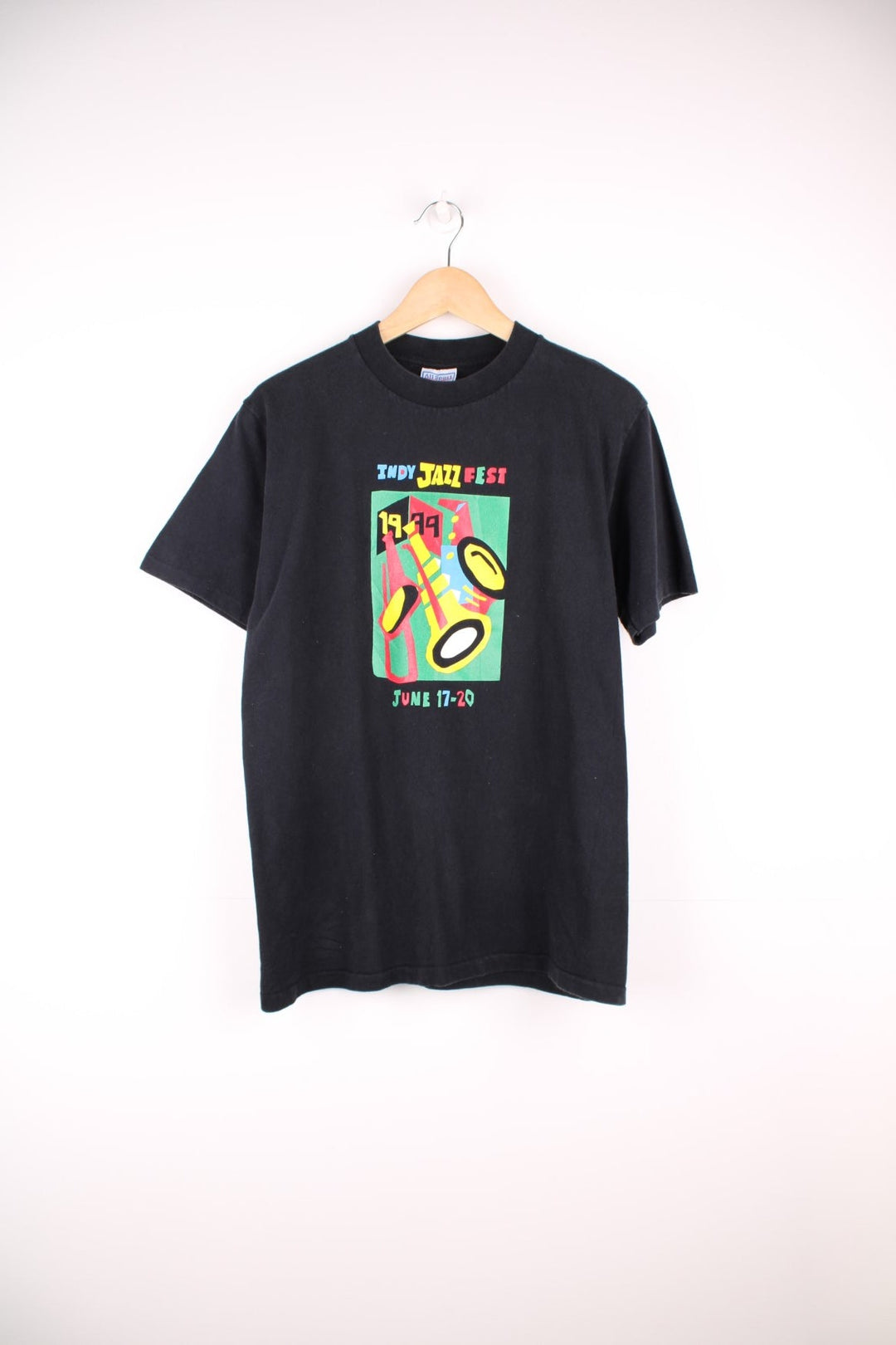 Black tee with text reading 'Indy Jazz Fest 1999 June 17-20 and a colourful geometric instrument graphic. 