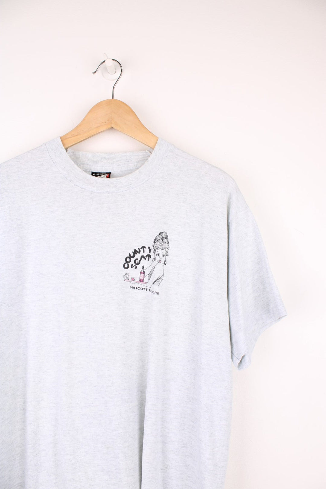 Vintage 90's single stitch "County Seat Bar & Grill" graphic t-shirt in grey colourway. Features 50's style waitress graphic on the front and back  