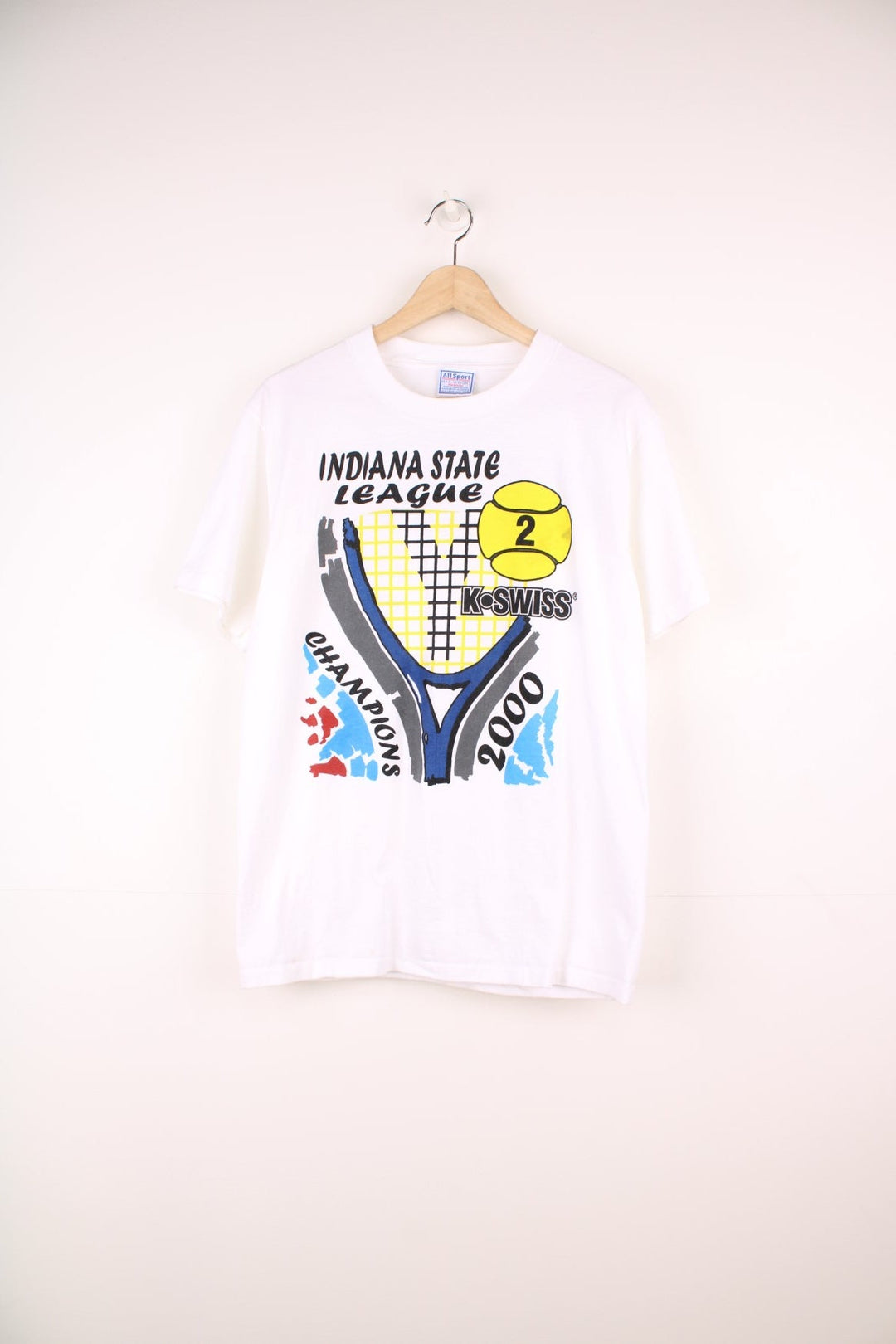 2000 'Indiana State League Champions' white spellout graphic tee with tennis racket and ball design and K. SWISS sponsor logo. Back graphic reading 'USA league tennis presented by Infiniti'.  