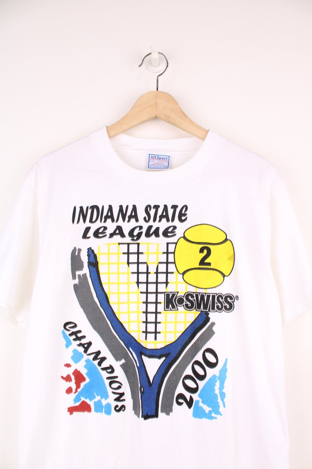 2000 'Indiana State League Champions' white spellout graphic tee with tennis racket and ball design and K. SWISS sponsor logo. Back graphic reading 'USA league tennis presented by Infiniti'.  