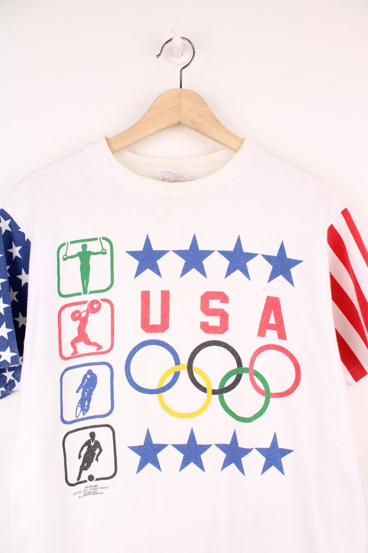 1989 Hanes Olympics USA graphic tee with US flag sleeve designs, and a front graphic of sports illustrations, stars, the Olympic rings, and a USA spellout.