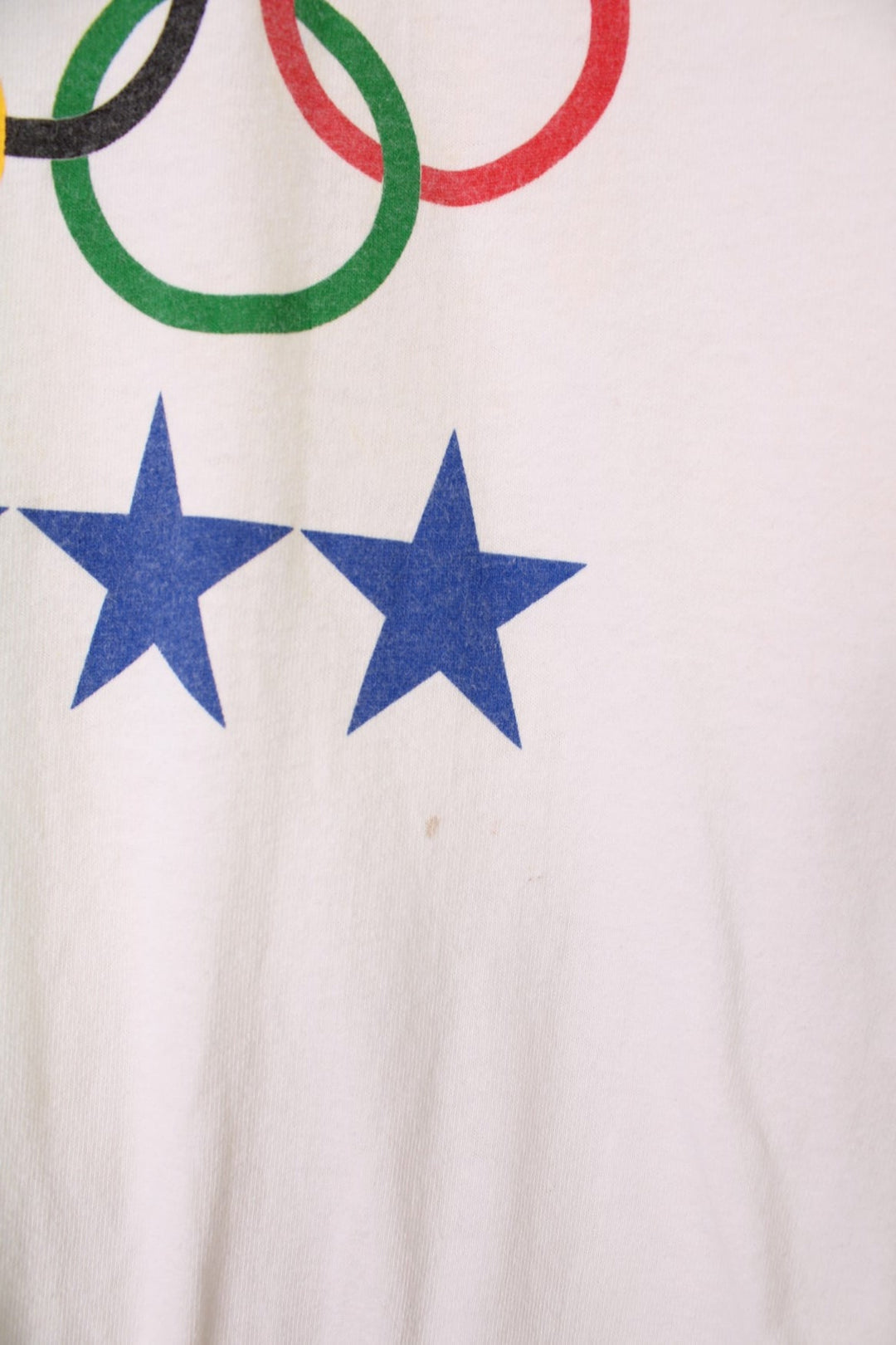 1991 Hanes Olympics USA graphic tee with US flag sleeve designs, and a front graphic of sports illustrations, stars, the Olympic rings, and a USA spellout.