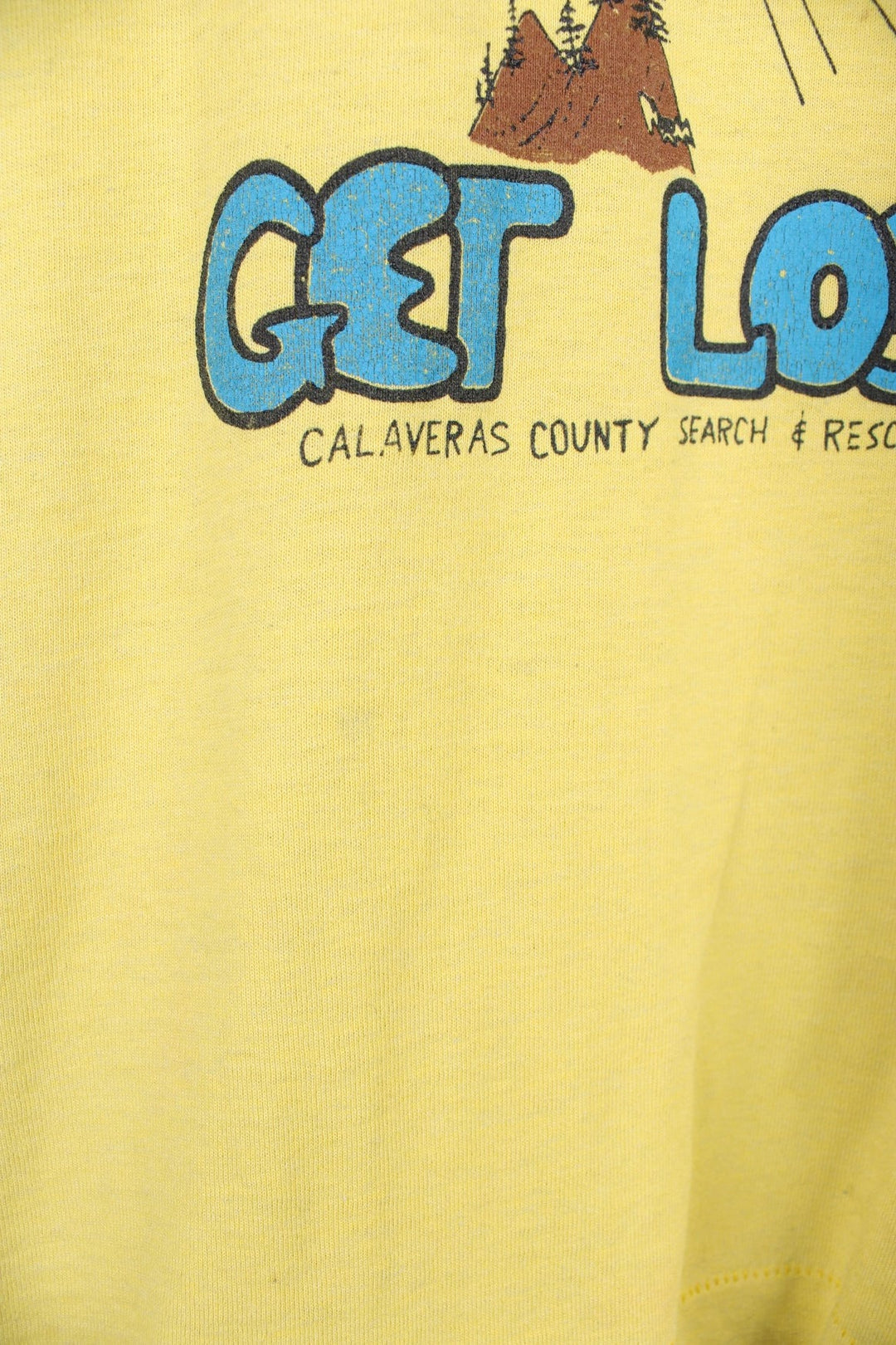 Vintage 80s Calaveras County Search & Rescue single stitch T-Shirt in yellow with graphic print and "Support Your Search And Rescue Get Lost" text on the front.