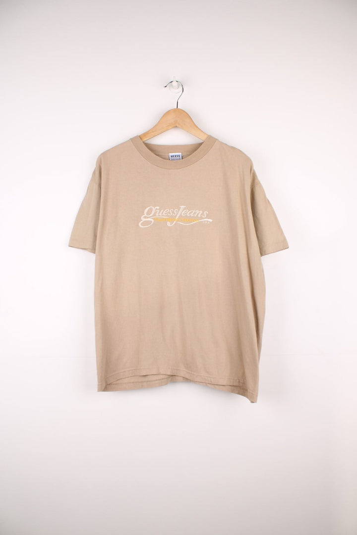 Vintage 90s Guess by Georges Marciano single stitch T-Shirt in a light brown colourway. Features embroidered Guess Jeans logo across the chest.