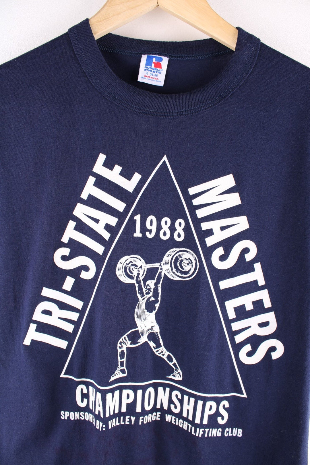 Vintage 1980s Russell Athletic T-Shirt in a navy blue colourway. The shirt has a large screen printed graphic of the 1988 Tri-State Masters Championships in Valley Forge Pennsylvania and has a single stitch hem, and was made in the USA. 