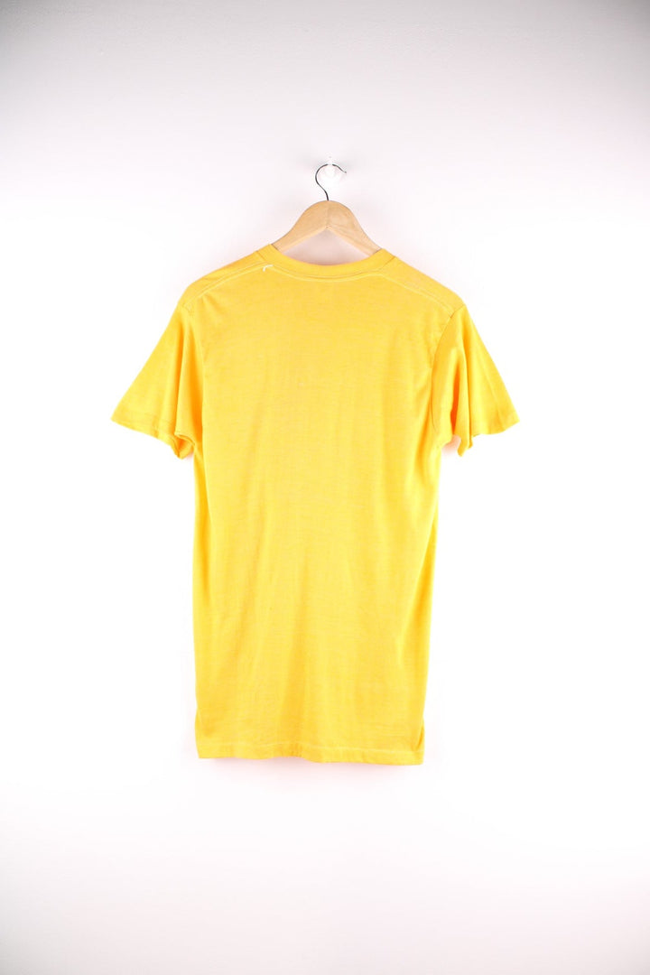 Vintage Screen Stars graphic T-Shirt in a yellow colourway. The shirt has a large red slogan printed on the front. Made in the USA. 