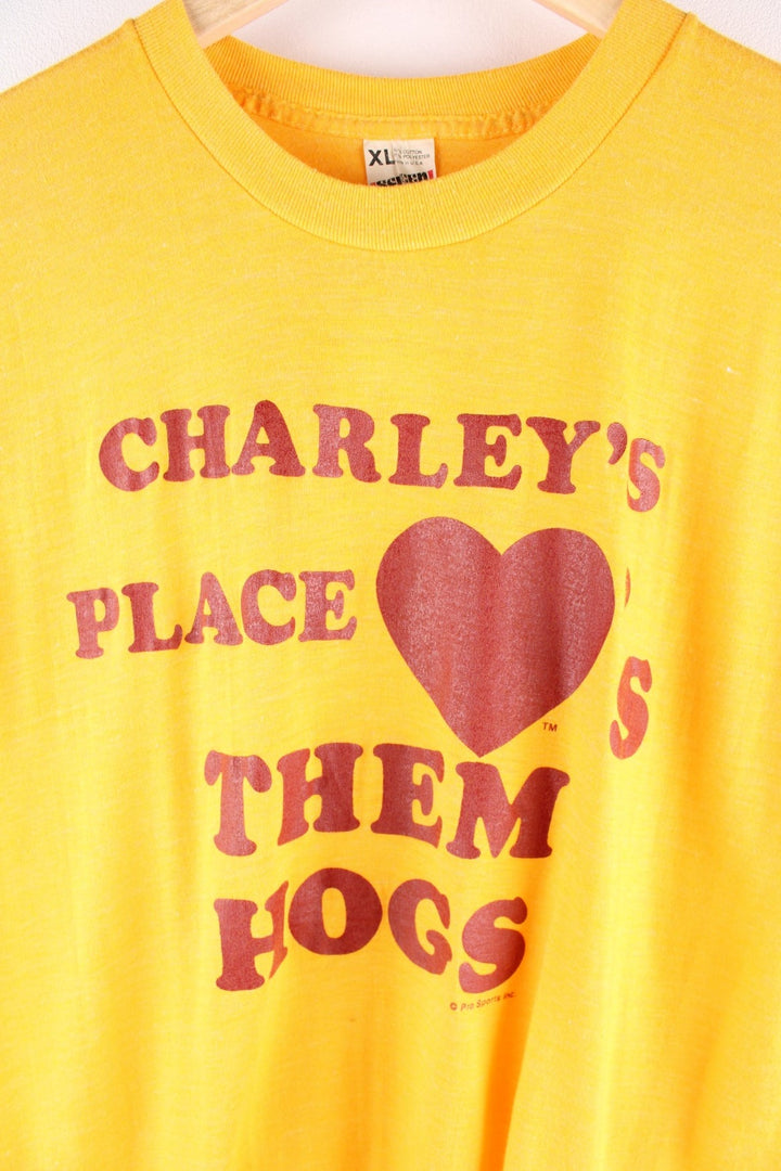 Vintage Screen Stars graphic T-Shirt in a yellow colourway. The shirt has a large red slogan printed on the front. Made in the USA. 