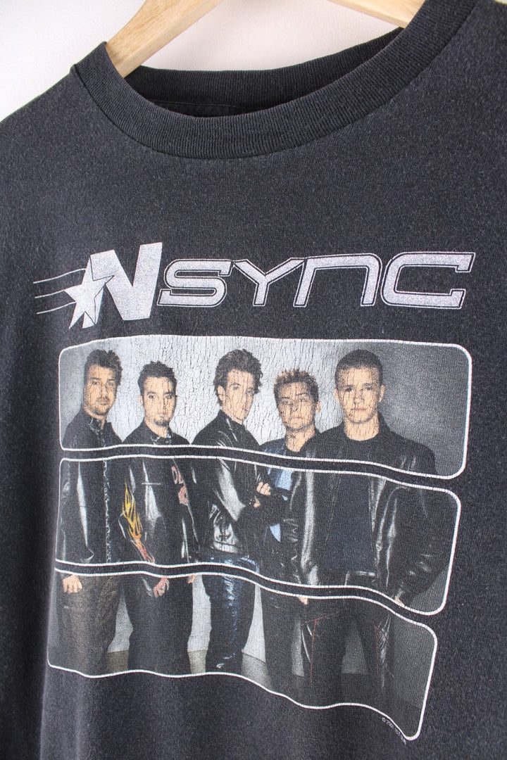 Vintage N Sync baby tee in a washed black colourway. The shirt has a large graphic image of the band printed on the front, and is dated to the year 2000. 