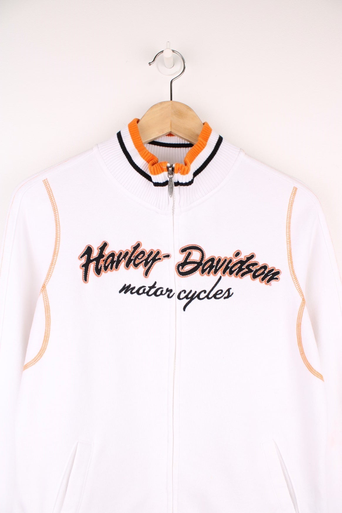 Harley-Davidson funnel neck zip through sweatshirt in a white, orange and black colourway. Features embroidered spell out logo across the chest and back.