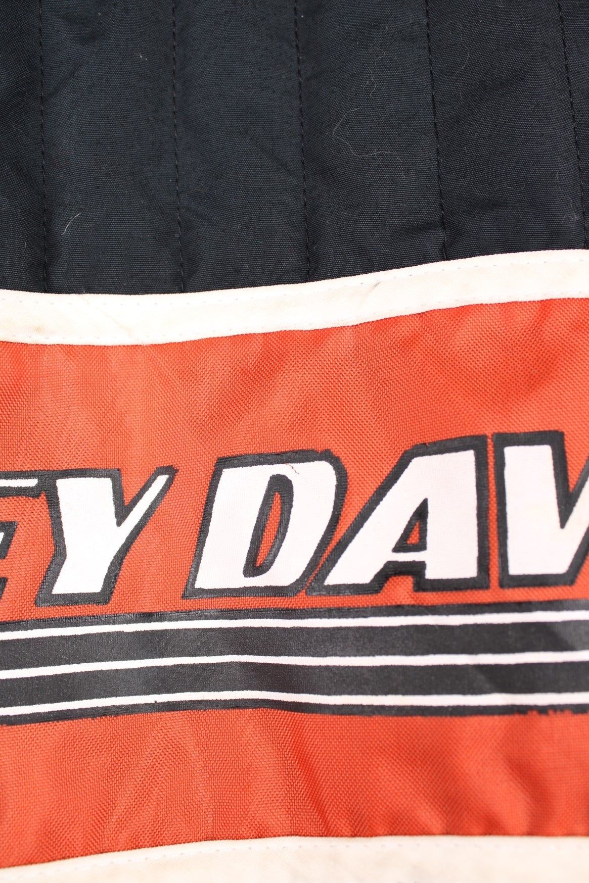 Harley-Davidson made in the USA black and orange motorcylce bomber jacket with embroiderd motif across the chest, badge on the shoulder and printed spell-out across the back of the shoulders