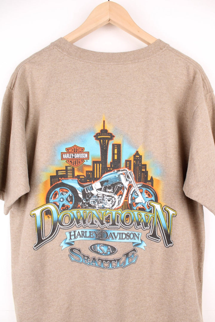 Vintage Harley Davidson Downtown Seattle T-Shirt in light brown. Features printed spell out logo across the chest and graphic print on the back.