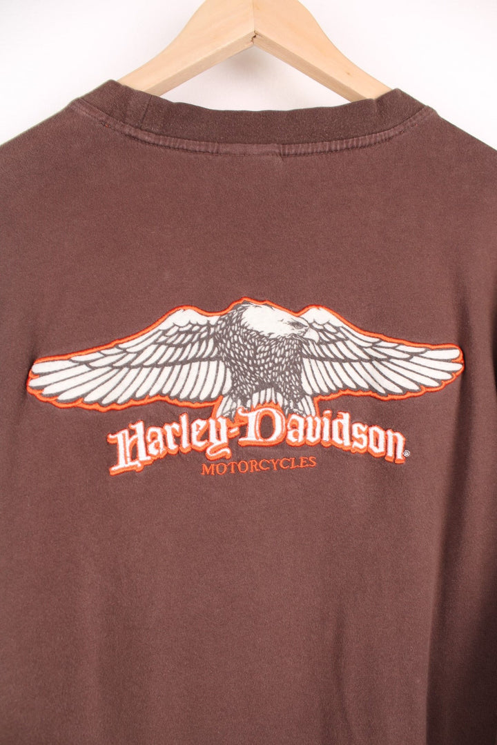 Harley Davidson Steel City, Washington, PA long sleeved top in brown. Features orange and white stripe down each sleeve, and embroidered spell out logo and eagle on the back. 