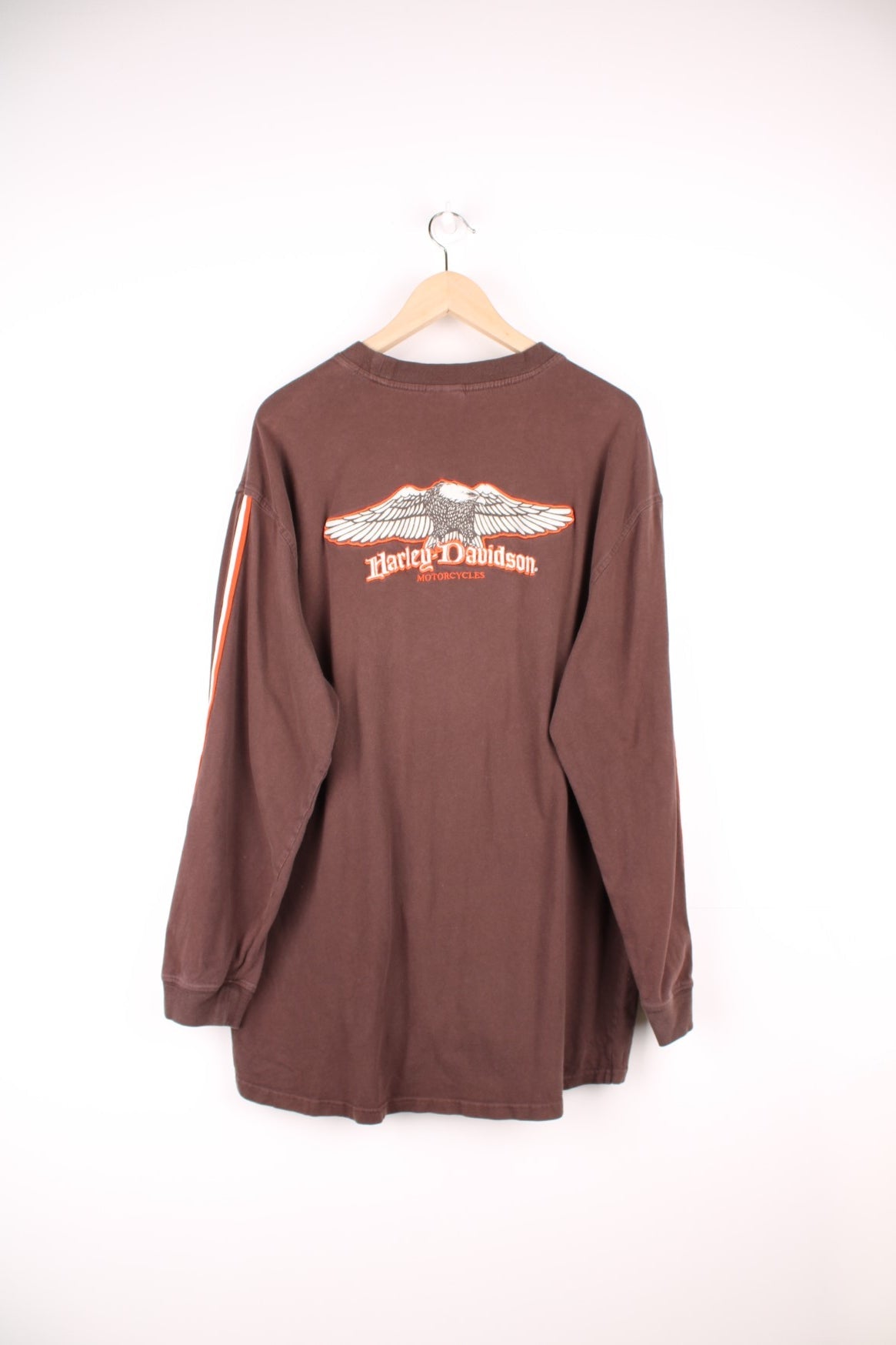 Harley Davidson Steel City, Washington, PA long sleeved top in brown. Features orange and white stripe down each sleeve, and embroidered spell out logo and eagle on the back. 