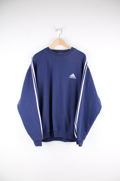 Adidas Sweatshirt in a blue and white colourway with three stripes going down the arms, crewneck, and has the logo embroidered on the front.