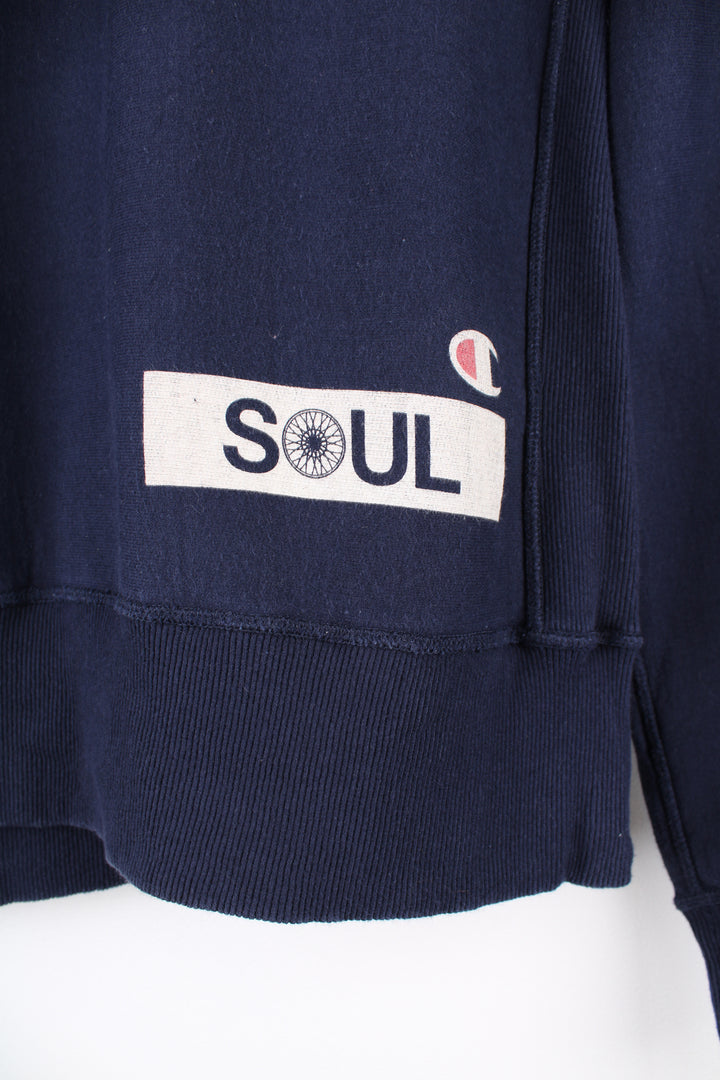 Champion x Tom Snyder Soul Cycle Sweatshirt in a blue colourway, crewneck, and has the logos printed on the front and back.