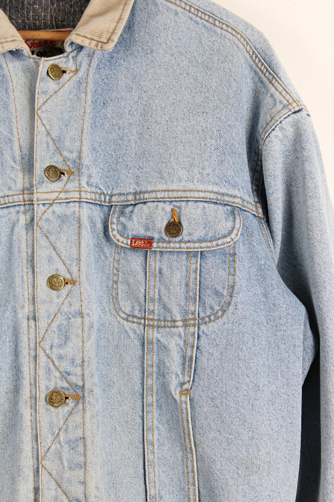 Vintage 80's Lee Storm Rider denim jacket in blue, has a fleece lining, button up with multiple pockets, and has a cream collar.