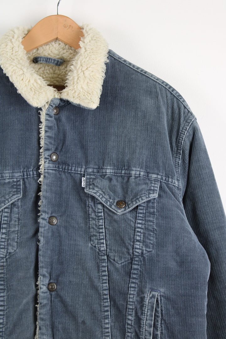 Levi's corduroy jacket in blue, button up with multiple pockets, and has a white sherpa lining. 