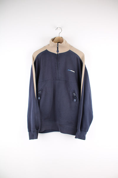 Reebok Sweatshirt in a blue and tanned colourway, half zip up, side pockets and has the logo embroidered on the front.