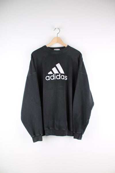 Adidas Sweatshirt in a faded black colourway, crewneck and has the logo spell out printed across the front.