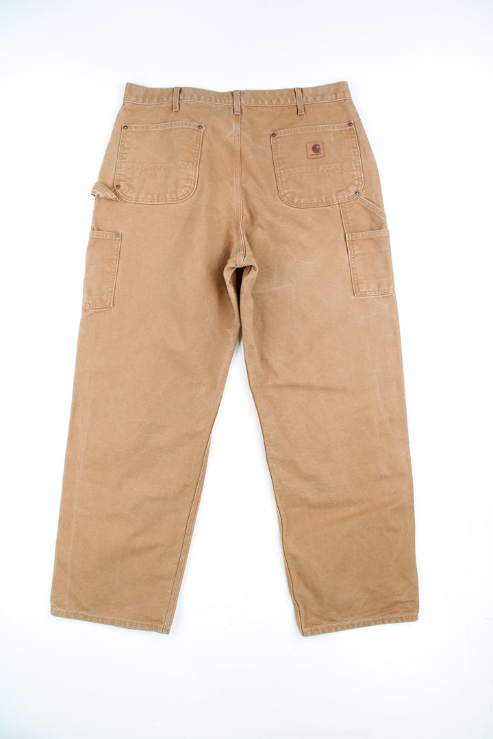 Tan Carhartt double knee carpenter jeans with multiple pockets with logo on the back pocket 