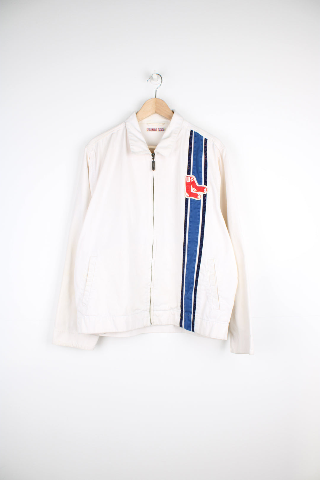 Vintage Boston Red Sox MLB, Moonlight Graham Coach Jacket in a white, blue and red colourway, zip up with side pockets, and has the the logo embroidered on the front alongside the blue stripes.