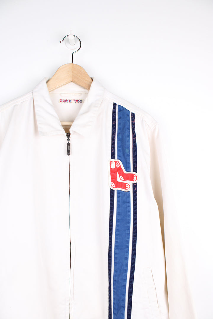 Vintage Boston Red Sox MLB, Moonlight Graham Coach Jacket in a white, blue and red colourway, zip up with side pockets, and has the the logo embroidered on the front alongside the blue stripes.