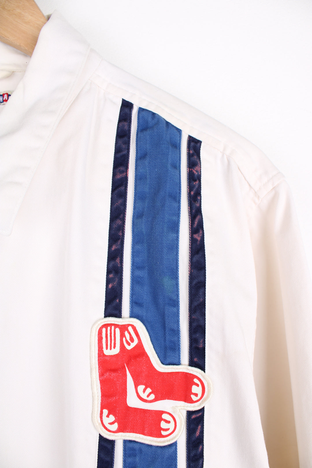 Vintage Boston Red Sox MLB, Moonlight Graham Coach Jacket in a white, blue and red colourway, zip up with side pockets, and has the the logo embroidered on the front alongside the blue stripes.