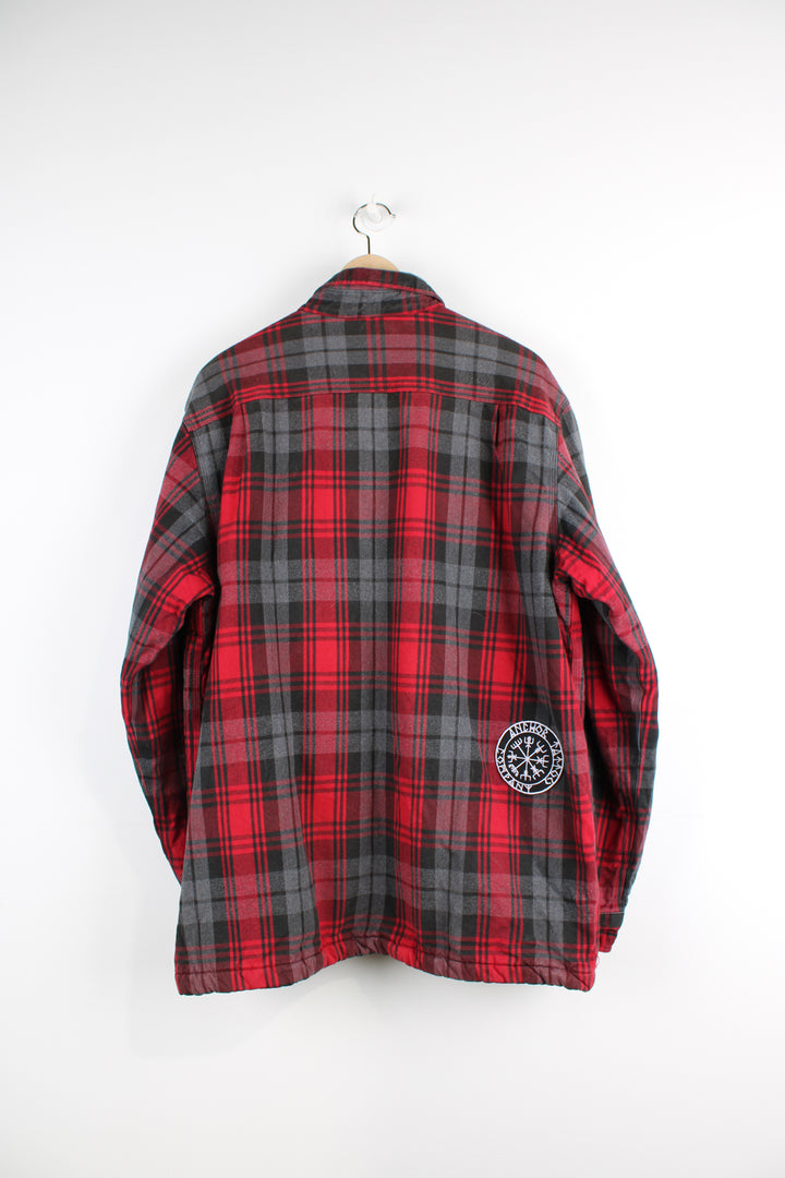 Red and grey Carhartt flannel shirt with fleece lining. Features popper buttons to close and Viking compass patch on the back.  good condition - small white paint mark by the pocket (see photos). Patch at the back has been added to cover a hole in the exterior fabric.  Size in Label:  Mens L