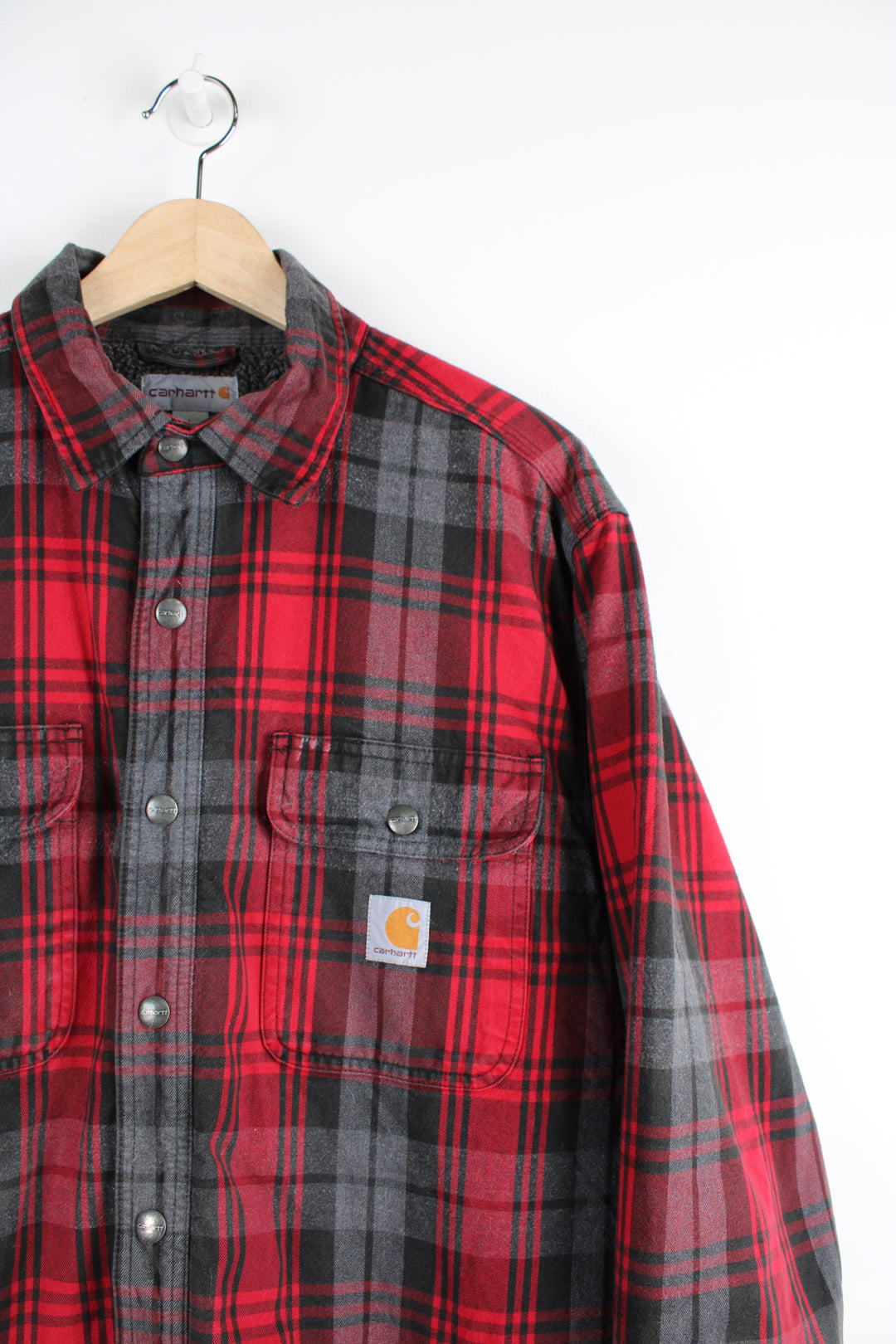 Red and grey Carhartt flannel shirt with fleece lining. Features popper buttons to close and Viking compass patch on the back.  good condition - small white paint mark by the pocket (see photos). Patch at the back has been added to cover a hole in the exterior fabric.  Size in Label:  Mens L