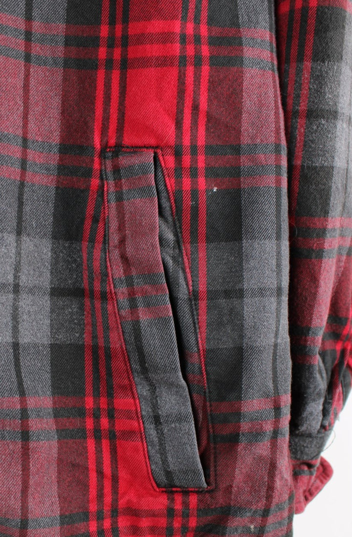 Red and grey Carhartt flannel shirt with fleece lining. Features popper buttons to close and Viking compass patch on the back.  good condition - small white paint mark by the pocket (see photos). Patch at the back has been added to cover a hole in the exterior fabric.  Size in Label:  Mens L