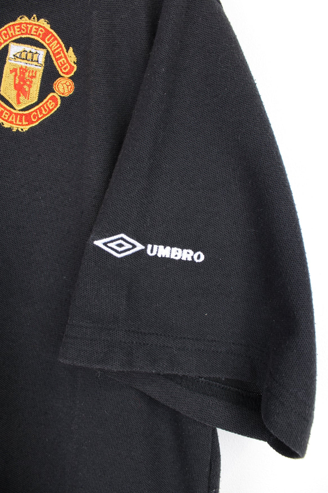 1998-99 Manchester United Umbro polo shirt in black, features embroidered badge and logo on the chest