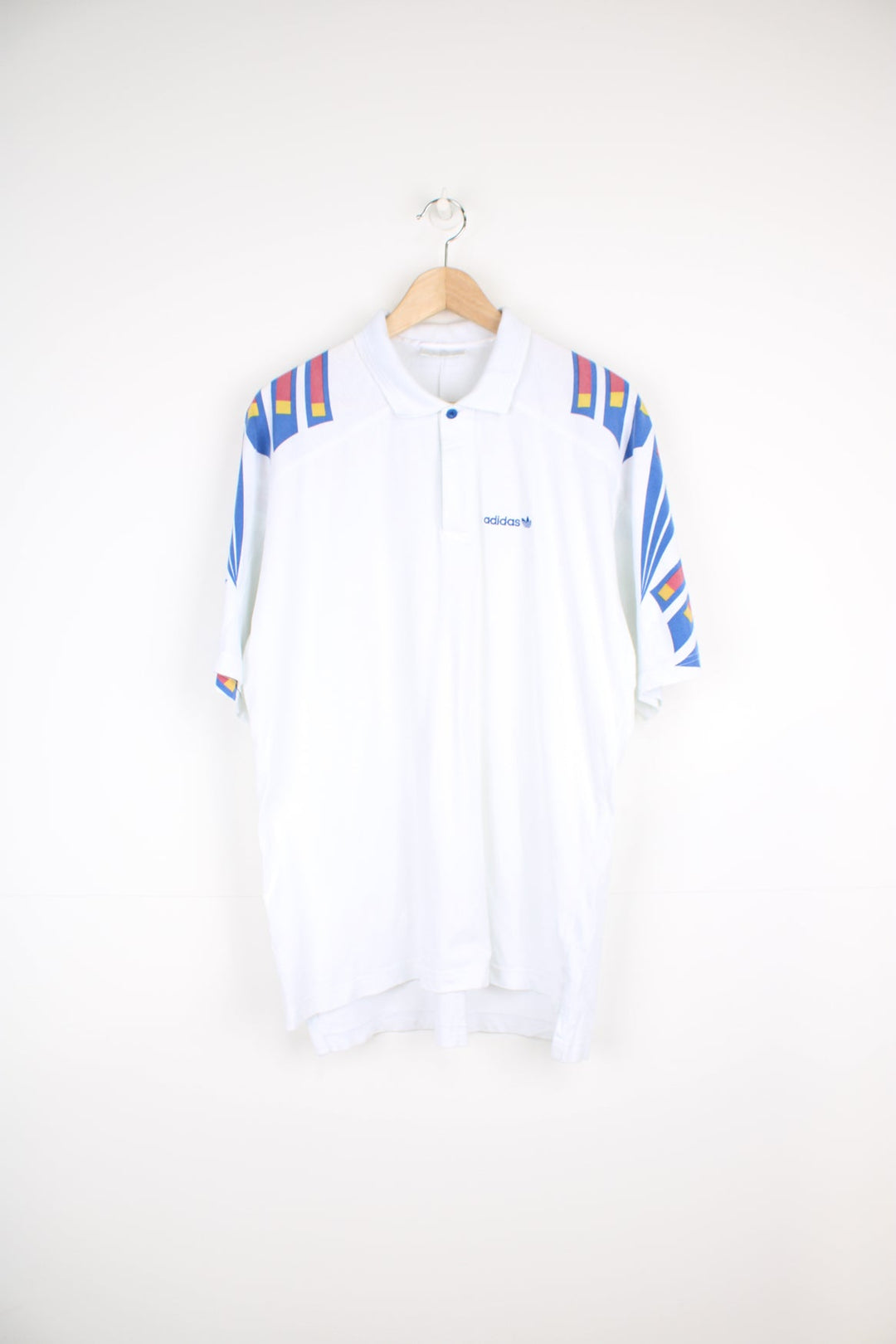 90's Adidas polo shirt in white, features geometric graphic on the shoulders and embroidered logo on the chest