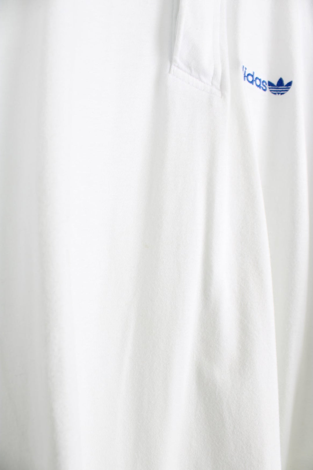 90's Adidas polo shirt in white, features geometric graphic on the shoulders and embroidered logo on the chest