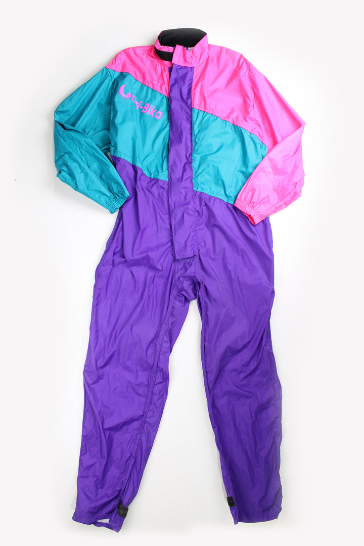 Vintage 80's Belstaff Dri Bika fold away waterproof coveralls. Pink and purple jumpsuit that folds away into a bag. Due to age the effectiveness of the waterproof fabric might be less. good condition - small mark on the front, scratches to the inside lining and some external scuffs Size in Label: Size L