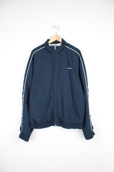 Vintage navy blue Reebok zip through track jacket with embroidered logo on the chest and spell-out down the sleeve
