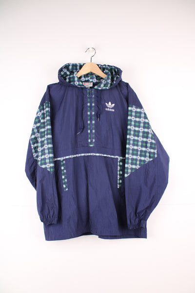 Adidas Pullover Windbreaker in a blue colourway with green and white tartan pattern throughout, hooded, half zip up, big pouch pocket, and has the logo embroidered on the front and back.