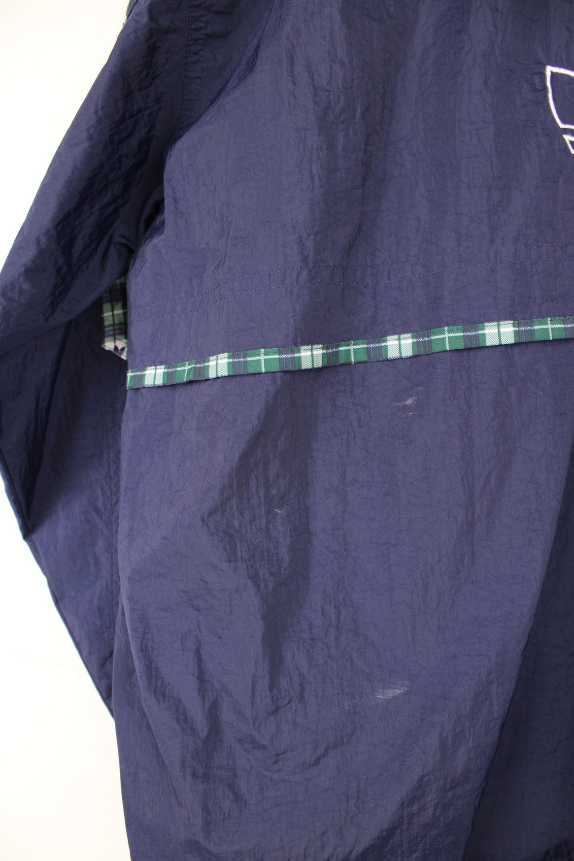 Adidas Pullover Windbreaker in a blue colourway with green and white tartan pattern throughout, hooded, half zip up, big pouch pocket, and has the logo embroidered on the front and back.