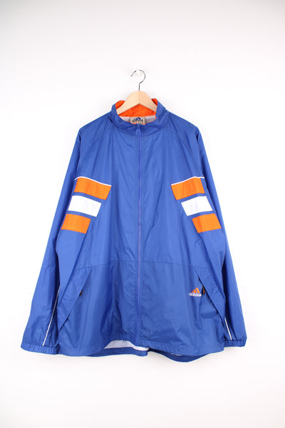 Adidas Windbreaker in a blue, white and orange colourway, zip up with side pockets, and has the logo embroidered on the front and left sleeve.