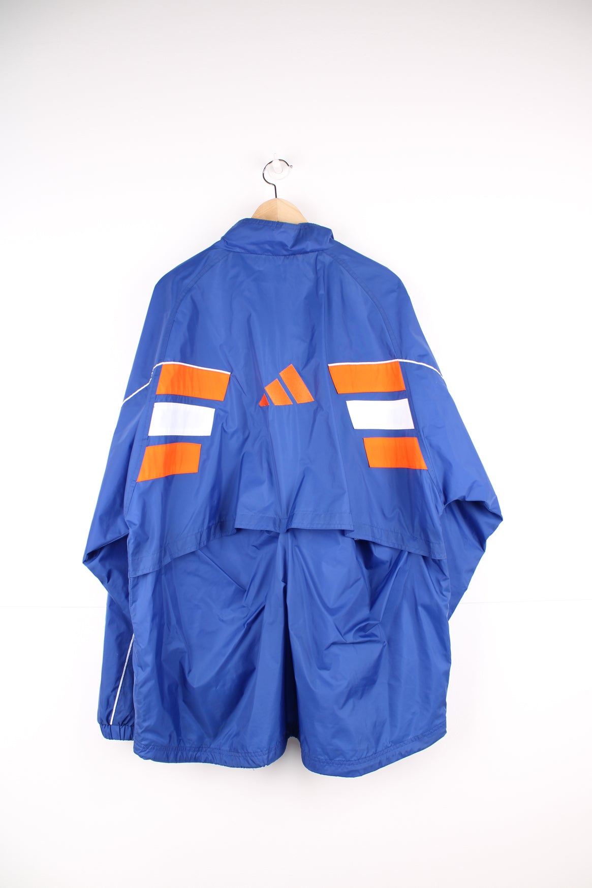 Adidas Windbreaker in a blue, white and orange colourway, zip up with side pockets, and has the logo embroidered on the front and left sleeve.