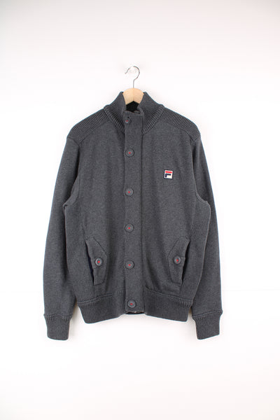 Fila Cardigan in a grey colourway, zip up and button up, side pockets, and has the logo embroidered on the front.