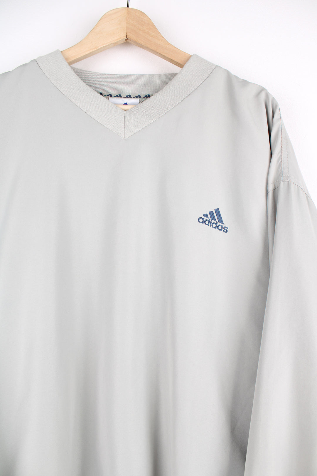 Adidas Training Top in a dark tanned colourway, v neck, side pockets, and has the logo embroidered on the front.