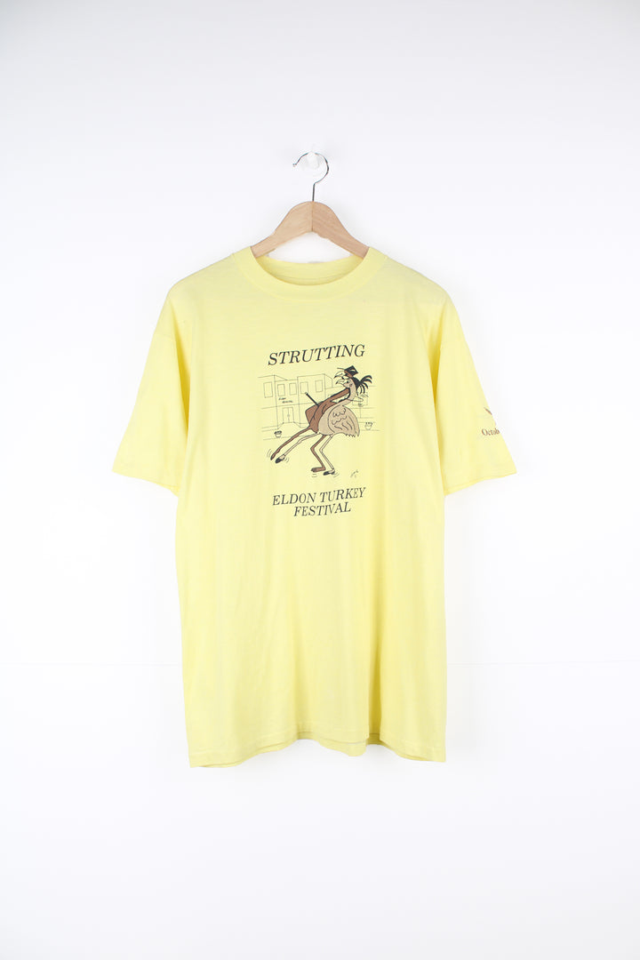 Vintage 1986 'Strutting' Eldon Turkey Festival in a pale yellow with printed graphic on the front, by Hanes